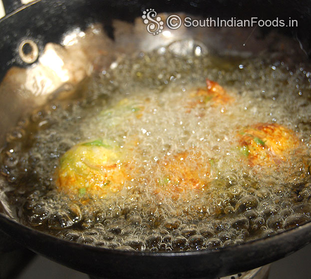 Heat enough oil, drop raw onion bonda