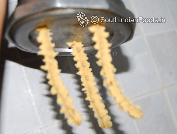 Put handful of dough in a murukku kuzhal, squeeze over the oil & deep fry till crisp & light brown on medium flame.