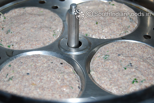 Grease idli plates with oil, pour batter, cover lid & steam it for 10 min.